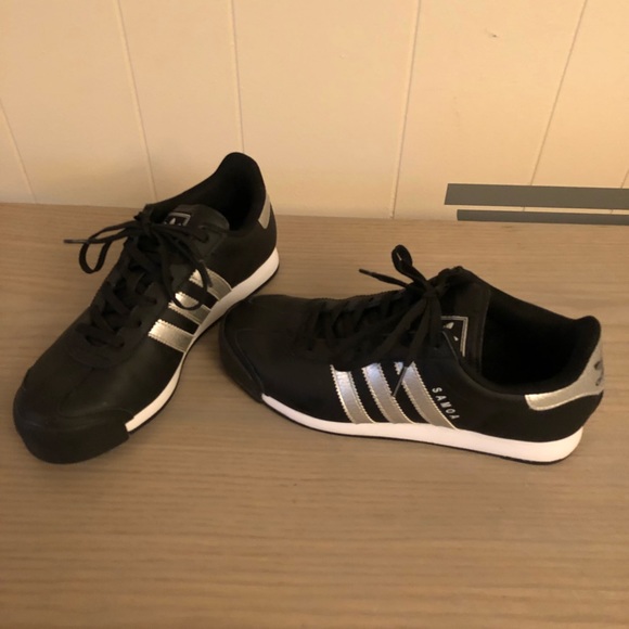 black adidas with silver stripes